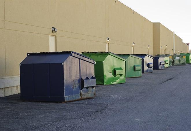 metal waste containers sit at a busy construction site in Amherst